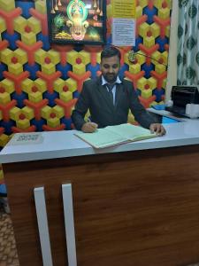 a man in a suit sitting at a counter at Hotel 7 star in Indore