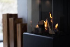 a fireplace with fire in it in a room at SAUERLAND CHALETS - "Die Chalets Herzenssache" in Winterberg