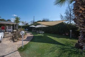 a backyard with a patio umbrella and a lawn at Villa Elpaix in Marsala