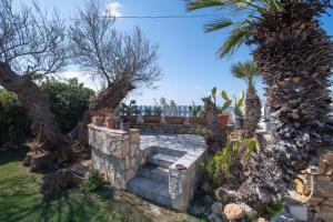 a stone bench in a garden with trees and plants at Villa Elpaix in Marsala