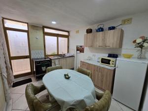 a kitchen with a table and a white refrigerator at Charming rustic getaway in Xaghra, Gozo. in Xagħra