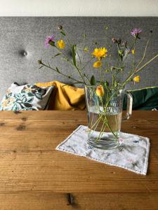 eine Glasvase mit Blumen auf dem Tisch in der Unterkunft Apartment Stillleben Luxus für die Seele in Abtenau