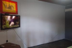 a tv hanging on a wall in a room at Casa espaçosa, piscina, churrasqueira , area festa in Corumbá