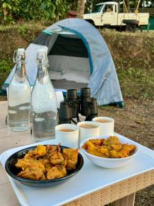 una mesa con un plato de comida y una tienda de campaña en Shrenya Orchidz-Coorg Nature Stay, en Madikeri