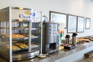 a bakery with a counter with trays of pastries at Colonial Flat Hotel in Itapetininga