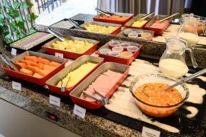 a buffet with several trays of different types of food at Colonial Flat Hotel in Itapetininga