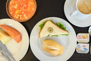 a table with two plates with sandwiches and a cup of coffee at Colonial Flat Hotel in Itapetininga