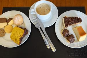 a table with two plates of food and a cup of coffee at Colonial Flat Hotel in Itapetininga