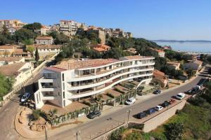 a large white building on a hill with a street at Appartement Sole - vue golfe de Porto Vecchio in Porto-Vecchio