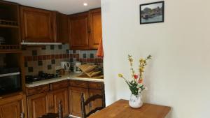 a kitchen with a table and a vase with flowers on it at La Cirerole in Casteil