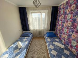 una piccola camera con due letti e una finestra di 4-х комнатная квартира в центра города Астана a Astana