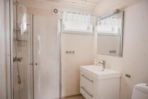 uma casa de banho com um chuveiro, um lavatório e um espelho. em FOSSEN CAMPING em Geiranger