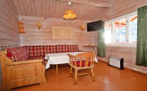 Habitación con sofá, mesa y TV. en FOSSEN CAMPING en Geiranger