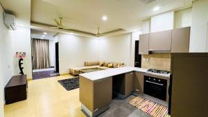 a kitchen with a stove and a living room at Eighteen Islamabad in Islamabad