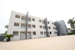 a white building with two poles in front of it at Colonial Flat Hotel in Itapetininga