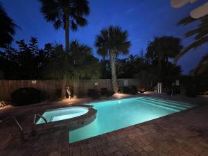 une piscine dans une cour la nuit dans l'établissement Seaside Retreat Cottages #1, à Clearwater Beach