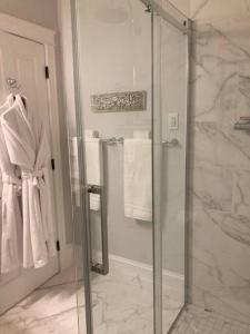 baño con ducha y puerta de cristal en The Red House Fredericton, en Fredericton