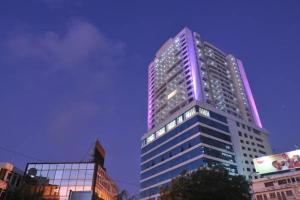 wysoki budynek z fioletowymi światłami w obiekcie Uhuru Heights Studio Apartment w mieście Dar es Salaam