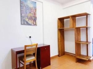 escritorio con silla y estante para libros en Uhuru Heights Studio Apartment en Dar es Salaam