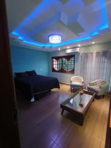 ein Wohnzimmer mit einem Bett und einem blauen Licht in der Unterkunft Residence Alto Padrão in Itaboraí