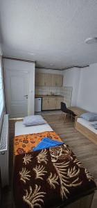 a room with two beds and a kitchen in it at Apartmani Roki in Tuzla