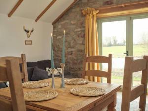 a wooden table with two candles on top of it at Noxon Pond Cottage in Clearwell