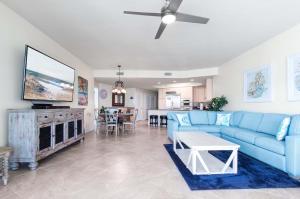 a living room with a blue couch and a tv at Caribe Resort Unit C1108 in Orange Beach