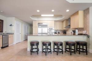 a kitchen with a bar with four stools at Caribe Resort Unit C1108 in Orange Beach