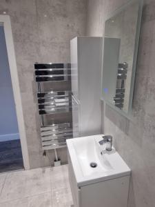 a white bathroom with a sink and a mirror at Richmond Apartments in London