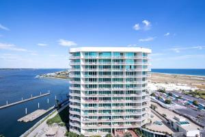 a tall white building next to a body of water at Caribe Resort Unit C1108 in Orange Beach