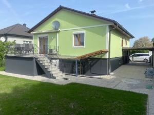 a green house with a porch and a driveway at AJO Vienna Ambassador Family House with Free Parking in Vienna