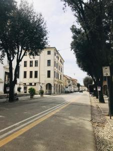 an empty street with buildings and trees on the side at Maison Revedin in Treviso