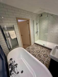 a bathroom with a bath tub and a shower at The Alma Inn in Sowerby Bridge