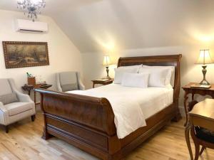 1 dormitorio con 1 cama grande y 2 sillas en The Red House Fredericton en Fredericton