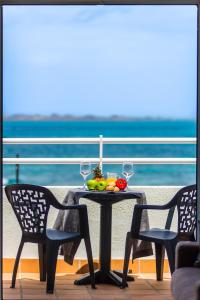 una mesa con copas de fruta y vino en el balcón en Dunas Club - Hotel & Apartamentos, en Corralejo