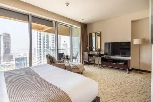 ein Hotelzimmer mit einem Bett und einem Flachbild-TV in der Unterkunft Frank Porter - Kempinski Central Avenue in Dubai