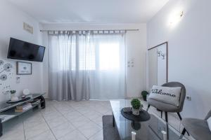 a white living room with a chair and a tv at Apartment Italia in Dubrovnik
