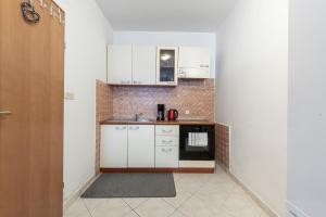 a small kitchen with white cabinets and a stove at Apartment Italia in Dubrovnik +25 photos