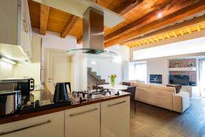 eine Küche und ein Wohnzimmer mit einem Herd mit Backofen in der Unterkunft Appartamento Stella - Verona Centro in Verona