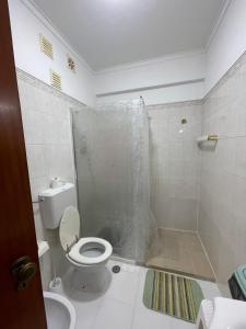 a bathroom with a shower with a toilet and a sink at Quarto Suite Relaxante in Almada