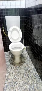 Łazienka z toaletą jest wyłożona czarno-białymi kafelkami. w obiekcie Monalissa One bedroom apartment w mieście Kisumu