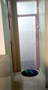 a bathroom with a door leading to a shower with a mat at Monalissa One bedroom apartment in Kisumu