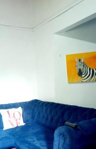 a blue couch in a room with a picture of a zebra at Monalissa One bedroom apartment in Kisumu