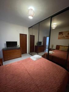 a room with two beds and a mirror at Quarto Suite Relaxante in Almada
