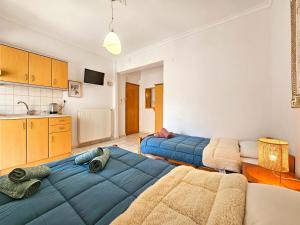 a living room with two beds and a kitchen at Hotel Exarhos in Paralia Katerinis