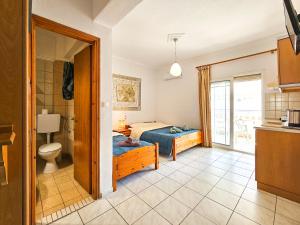 a bedroom with a bed and a bathroom at Hotel Exarhos in Paralia Katerinis