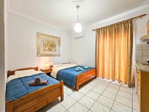a bedroom with two beds and a window at Hotel Exarhos in Paralia Katerinis