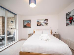 um quarto branco com uma cama grande e uma janela em London Apartment near Tower Bridge and Tube Pass the Keys em Londres