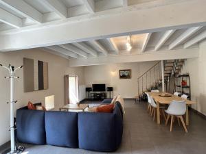 sala de estar con sofá azul y mesa en Petit Moulin De Veillard, en Bourg-Charente