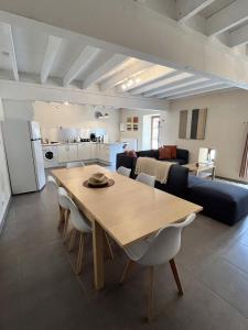 comedor y sala de estar con mesa y sillas en Petit Moulin De Veillard, en Bourg-Charente